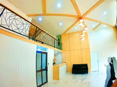 a woman is standing in a lobby with a staircase at El Huq in Bangkok