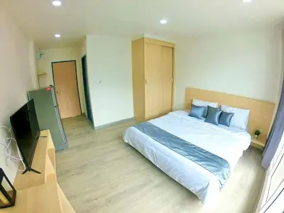 a bedroom with a large bed and a flat screen tv at El Huq in Bangkok