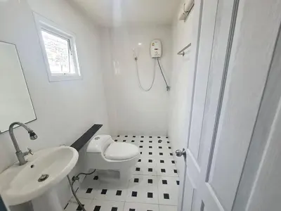 a white bathroom with a toilet and a sink at El Huq in Bangkok