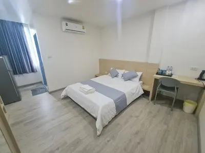 a bedroom with a bed and a desk and a desk at El Huq in Bangkok
