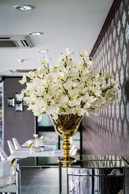 a vase filled with white flowers on a table at Lux Boutique Hotel in Nonthaburi