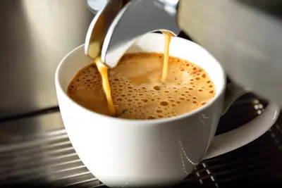 a cup of coffee with a spoon in it at Lux Boutique Hotel in Nonthaburi