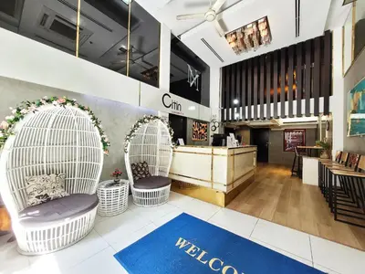 a lobby with two white wicker chairs and a counter at Citin Sukhumvit 11 Nana Bangkok by Compass Hospitality in Bangkok
