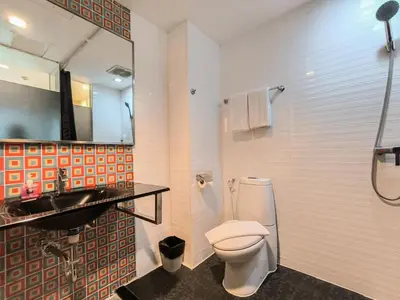 a bathroom with a toilet and a sink and a mirror at Citin Sukhumvit 11 Nana Bangkok by Compass Hospitality in Bangkok