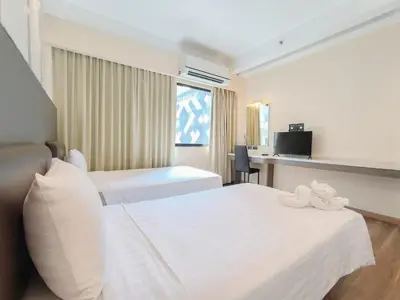 a hotel room with two beds and a desk at Citin Sukhumvit 11 Nana Bangkok by Compass Hospitality in Bangkok