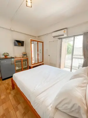 a bedroom with a large white bed and a window at Pranot Apartment & Spa in Nonthaburi