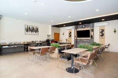 a restaurant with tables and chairs and a counter at Amanah Bangkok Hotel in Bangkok