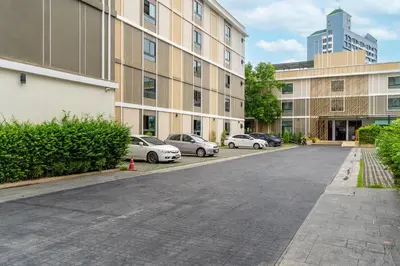 an empty street with cars parked in front of buildings at Amanah Bangkok Hotel in Bangkok