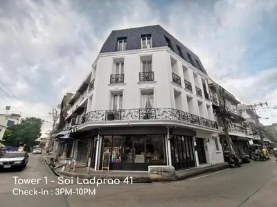 a white building on the corner of a street at Double Bed Hotel in Bangkok