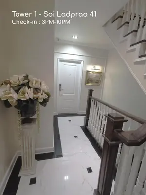 a stairway with a vase of flowers in a hallway at Double Bed Hotel in Bangkok