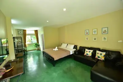 a living room with a bed and a couch at BaanSuanklaiKlungBangkrachao บ้านสวนใกล้กรุงบางกะเจ้า in Phra Pradaeng