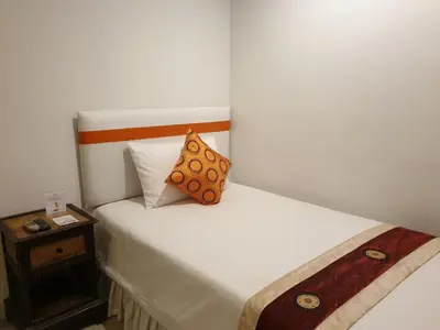 a bedroom with two beds with a pillow on it at Arawana Residence Phromphong in Bangkok