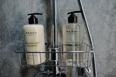 two bottles of soap in a metal rack at Baan Khun Pra Duplex Rm3 Bangkok in Bangkok