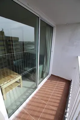 a balcony with glass doors and a bench on it at Lee Place Phatthanakan Condo in Bangkok