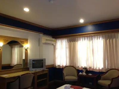 a hotel room with a television and a mirror at Suda Palace in Bangkok