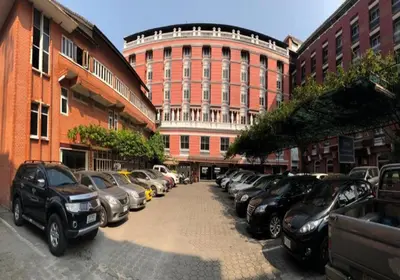 a row of cars parked in front of a building at Suda Palace in Bangkok