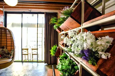 a room with a bunch of flowers on a wall at Hidden Habitat - Design Guesthouse in Bangkok