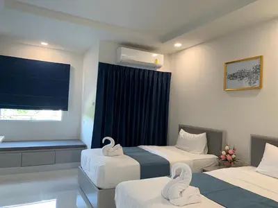 a hotel room with two beds and a window at Icare Residence & Hotel in Bangkok