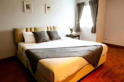 a bedroom with a large bed in a room at Bellevue Boutique Bangkok in Amphoe Phra Khanong