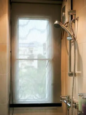 a window in a bathroom with a shower curtain at Bellevue Boutique Bangkok in Amphoe Phra Khanong