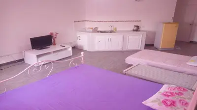 a room with two beds and a tv in it at Impact Don Mueang Bangkok Guest House in Thung Si Kan