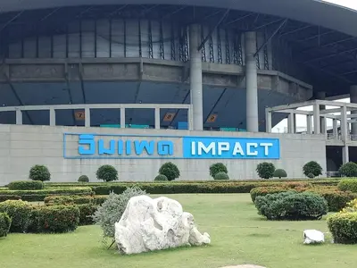 a building with a sign in front of a stadium at Impact Don Mueang Bangkok Guest House in Thung Si Kan