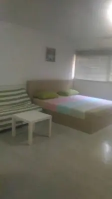 a bedroom with two beds and a table in it at Airport Transfer Bangkok apartment in Thung Si Kan