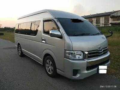 a silver van is parked on a road at Thailand Taxiapartment Hostel in Thung Si Kan