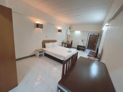 a bedroom with a bed and a desk in a room at โรงแรมวินบางนา Win Bangna Hotel in Bangna