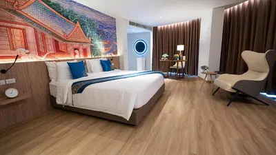 a bedroom with a large bed with a painting on the wall at Pannarai Hotel Bangkok-Pra tunam in Bangkok