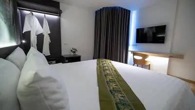 a hotel room with a large white bed and a television at Pannarai Hotel Bangkok-Pra tunam in Bangkok