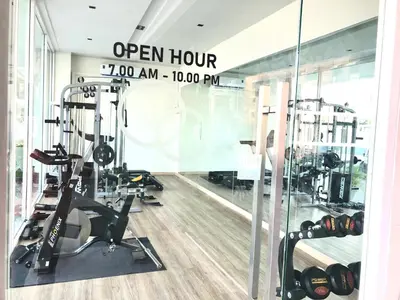 a gym with treadmills and machines in a room at LeeNova Place in Lat Krabang