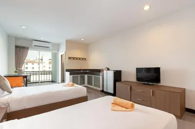 a hotel room with two beds and a television at LeeNova Place in Lat Krabang