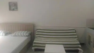 a small room with a bed and a chair at Airport Transfer Bangkok apartment in Thung Si Kan