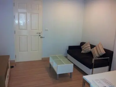 a living room with a black couch and a white door at Near Impact Challenger Bangkok Thailand in Nonthaburi