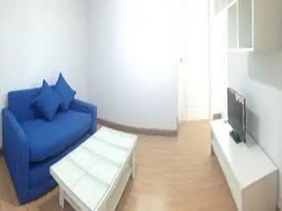 a living room with a blue couch and a tv at Near Impact Challenger Bangkok Thailand in Nonthaburi