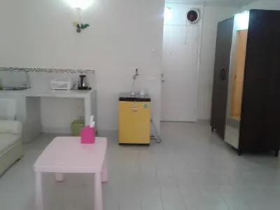 a room with a pink table and a yellow cabinet at Asia Don Mueang Bangkok Condominium in Thung Si Kan