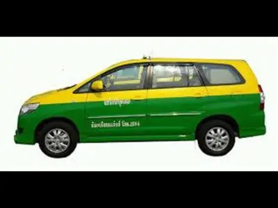 a green and yellow van parked on a street at Asia Don Mueang Bangkok Condominium in Thung Si Kan