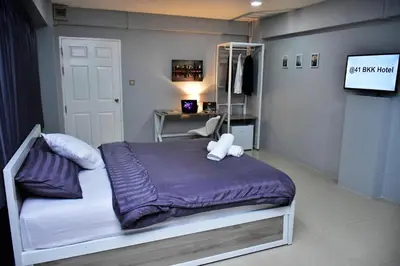 a bedroom with a bed and a desk and a television at 41BKK Hotel Rama9 in Bangkok