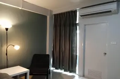a room with a bed and a chair and a window at 41BKK Hotel Rama9 in Bangkok