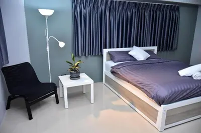 a bedroom with a bed and a chair and a lamp at 41BKK Hotel Rama9 in Bangkok