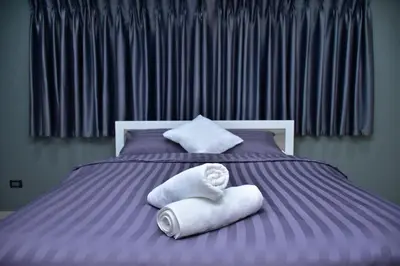 a purple bed with towels on top of it at 41BKK Hotel Rama9 in Bangkok