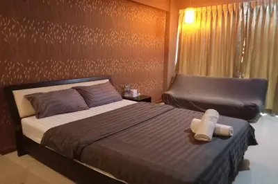a bedroom with a large bed and a chair at 41BKK Hotel Rama9 in Bangkok