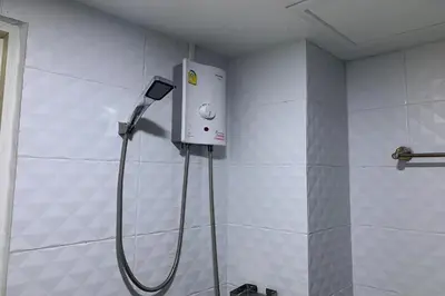 a shower in a bathroom with a hose attached to a wall at 41BKK Hotel Rama9 in Bangkok
