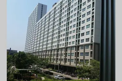 a large building with motorcycles parked in front of it at Nice Condo near Ramkhamhaeng 60, Lam Sali MRT in Bangkok