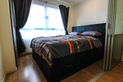 a bed in a room with a window and a mirror at Nice Condo near Ramkhamhaeng 60, Lam Sali MRT in Bangkok
