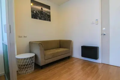 a living room with a chair and a tv at Nice Condo near Ramkhamhaeng 60, Lam Sali MRT in Bangkok