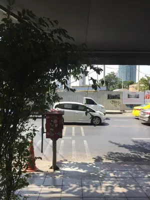 a white car is parked in a parking lot at Bangkok Hub Hostel in Bangkok