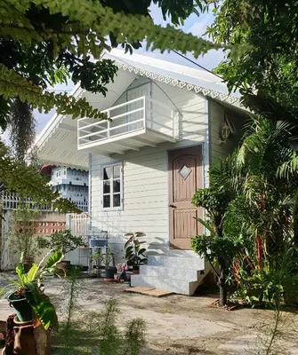 a white house with a porch and a door at KINN Stay50 Bangkok in Bangkok Yai