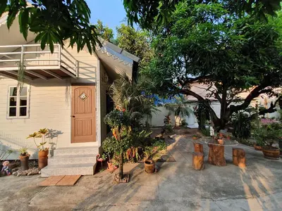 a house with a lot of plants and a tree at KINN Stay50 Bangkok in Bangkok Yai